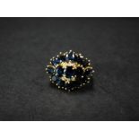 An 18ct. gold diamond and sapphire twenty one stone ring, the oval cut sapphires around the