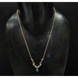 A 9ct. hallmarked gold emerald and diamond pendant necklace, the oval cut emerald of 0.20ct spread