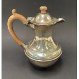 A George VI silver baluster hot water jug with fruitwood handle and finial by Richard Comyns, London