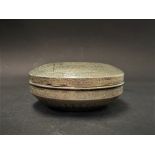 An Egyptian white metal circular box with engraved decoration and Islamic script, stamped marks to