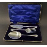 An Edwardian cased set of three cake serving implements, comprising a fork, a cake slice and