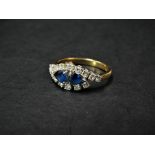 A modern 18ct. gold diamond and sapphire set sixteen stone ring, the two pear shaped sapphires of