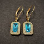 A pair of topaz and diamond chip 9ct. gold drop earrings, each of the baguette cut topaz of 0.