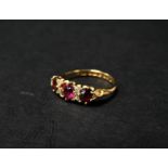 An attractive Edwardian 18ct. gold diamond and ruby seven stone ring, the central oval ruby