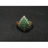 A contemporary 9ct. hallmarked gold diamond and emerald cluster ring, the head of lozenge shape with