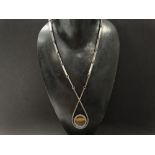 A good Danish silver Modernist design pendant necklace, the pendant set with a raw tigers eye core