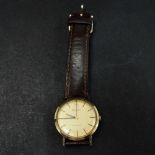 A Bulova Longchamps 9ct. gold cased manual wind wristwatch, the 28mm champagne dial with gilt