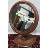 A walnut framed mahogany toilet mirror on turned base.