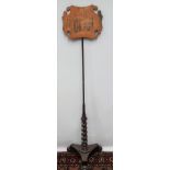 A 19th century mahogany pole screen and stand, the screen decorated with penwork of a family group.