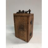 A Ford model T ignition coil in wooden case.