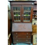 An English oak Arts & Crafts style bureau bookcase with leaded panels above a traditional bureau