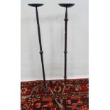 Two wrought iron floor standing pricket candlesticks upon tripod supports, height 78cm.