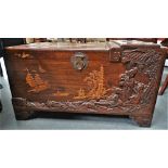 A 20th century Chinese camphor wood chest with raised inlaid carved panels of figures, ships and