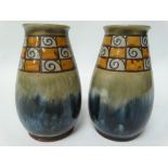 A pair of Royal Doulton stoneware ovoid vases with incised band on a green and blue mottled ground