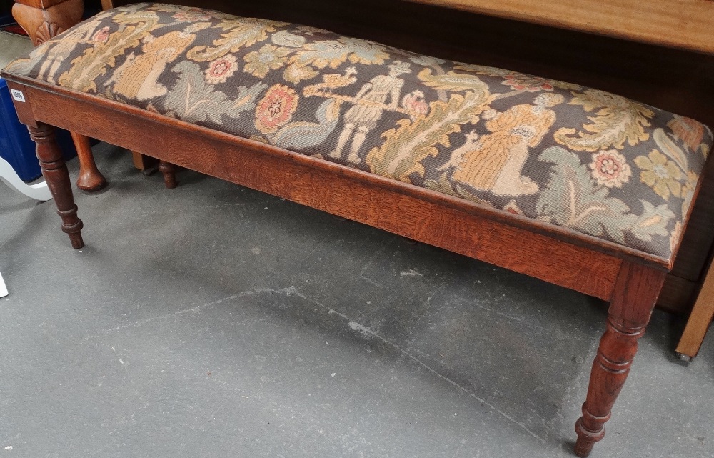 An Edwardian oak framed piano stool with an 18th century style woolwork seat.