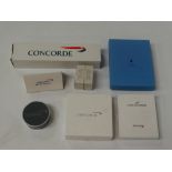 Six Concorde collectable items, including a notebook, a wallet, a bottle label etc.