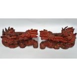 A pair of early 20th century Chinese red lacquer and gilded opposing Buddhistic lion carvings,