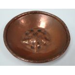 An Arts & Crafts copper embossed circular pin dish by Hugh Wallis with central flowerhead boss,