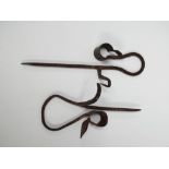 Two interesting wrought iron spike wall mounting rush or candle light holders, length of longest