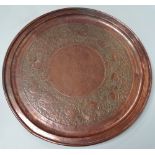 An Arts & Crafts copper circular tray embossed with geese amongst foliate scrolls, diameter 57.5cm.