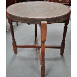 A middle eastern brass topped occasional table embossed with scripture on a typical oak turned