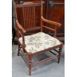 An Arts & Crafts style stickback low armchair with turned framed and double stretchers.