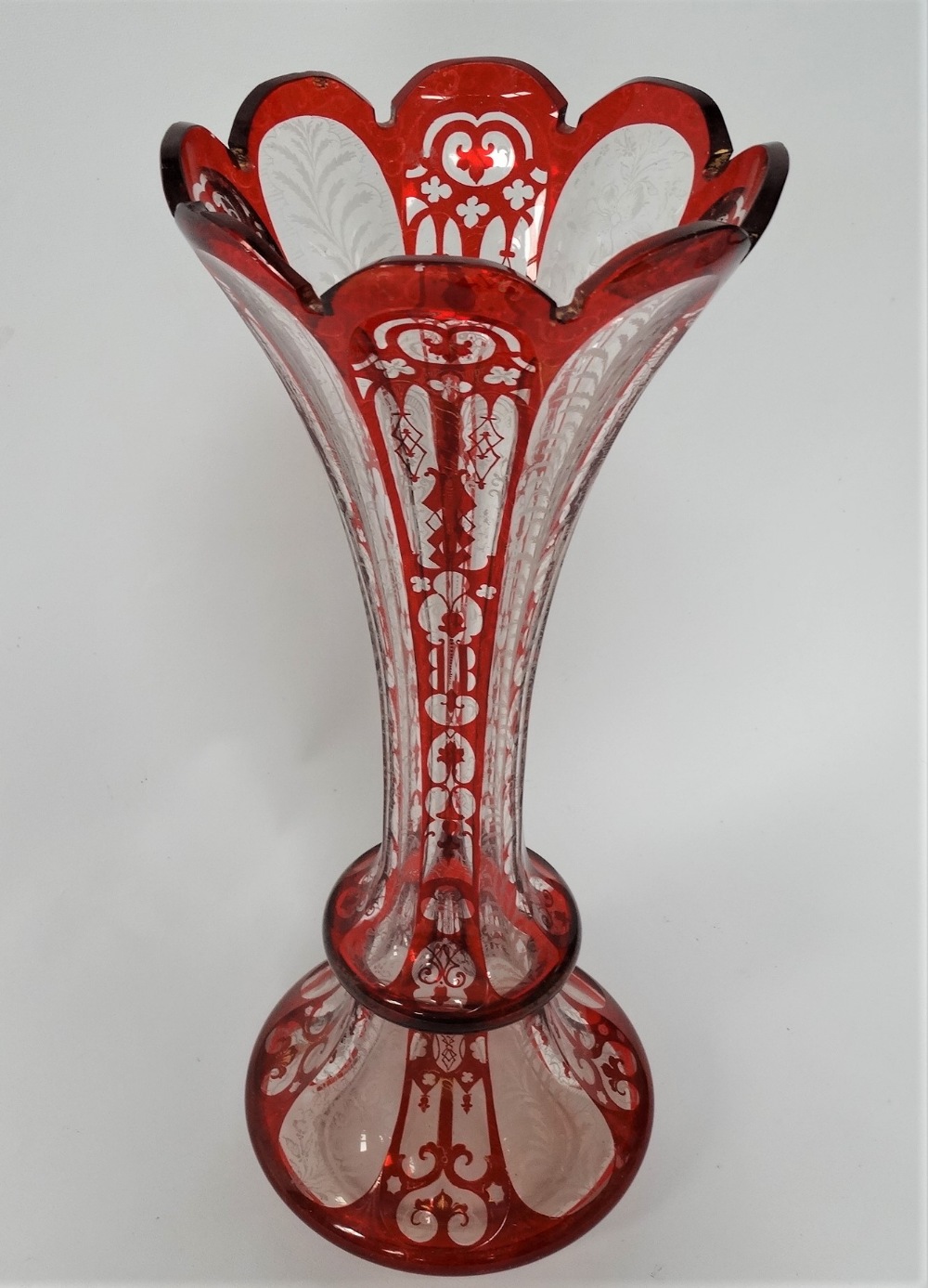 A Bohemian glass ruby overlay and white enamel and gilt painted flared vase, height 39.5cm (rim - Image 2 of 2