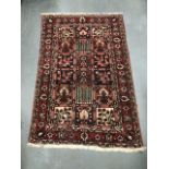 A 20th century Persian Bakhtiari hand knotted wool rug decorated with three rows of six square