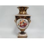An early 19th century Crown Derby porcelain pedestal vase painted with a circular reserve still life
