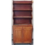 An early 19th century mahogany bookcase cabinet with waterfall shelves above two drawers and a