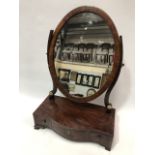 A George III mahogany crossbanded and boxwood and ebony inlaid dressing table swing mirror, the oval