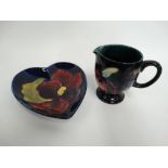 A Moorcroft iris decorated cream jug, together with a heart shaped pin dish, height of jug 7cm.