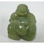 A Chinese celadon green jadeite carved portly jovial Buddha, height 4cm.