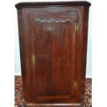 A late 18th century oak hanging corner cabinet fitted with blind door and 'H' hinges.