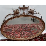 A 19th century gilt decorated Adams style oval wall mirror, the cresting with griffins and
