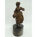 A 19th century bronze sculpture of a woman in 18th century dress holding a wheat sheaf and on