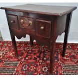 A mid 18th century and later oak lowboy fitted with three drawers above a shaped apron and square