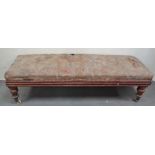 A large William IV window seat raised on turned and acanthus decorated legs with brass castors,