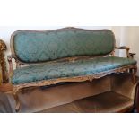 A 19th century gilt framed and carved sofa in mid 18th century style upholstered in green fabric.