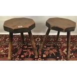 A pair of elm seat octagonal section stools upon three legs, height 38cm.