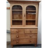 A 19th century Cornish stripped pine dresser with glazed doors over three drawers, width 136cm.