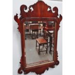 A George III mahogany wall mirror with pierced and scrolling frame, gilding and bevel edged plate,