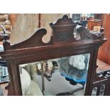A late 19th century walnut overmantle mirror with classical influenced decoration and bevel edge