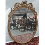 A large Victorian oval mirror with foliate gesso scrolling and shell decoration, height 145cm.