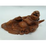 A Chinese root carving, carved as a jovial portly gentleman with a frog, with glass eyes and ivory