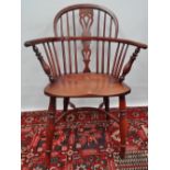 A yew and elm Windsor armchair with saddle seat and bow stretcher.