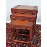 A nest of four Chinese carved hardwood occasional tables, width 81cm.