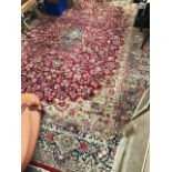 A Kerman hand knotted carpet, with foliate scroll decoration on a burgundy ground and within