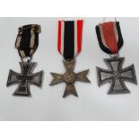 A WWI German 1914 Iron Cross, together with a 1939 Third Reich German Iron Cross and a 1939 Merit
