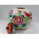 A Chinese provincial famille rose decorated ovoid ginger jar with wooden cover, decorated with a
